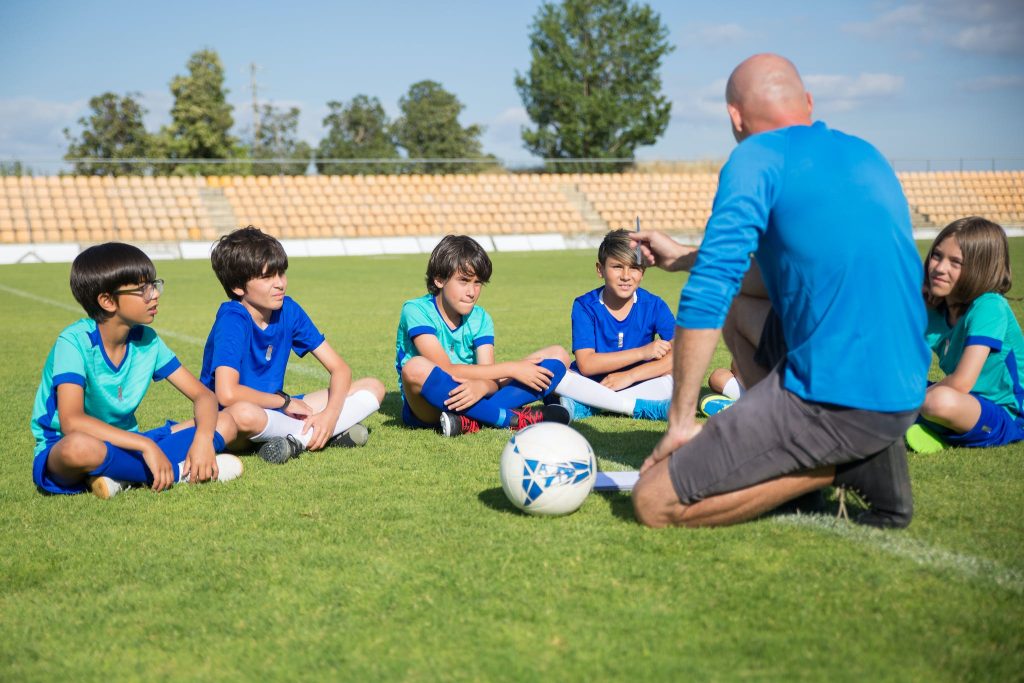 A Coach Teaching Children at a Soccer Field